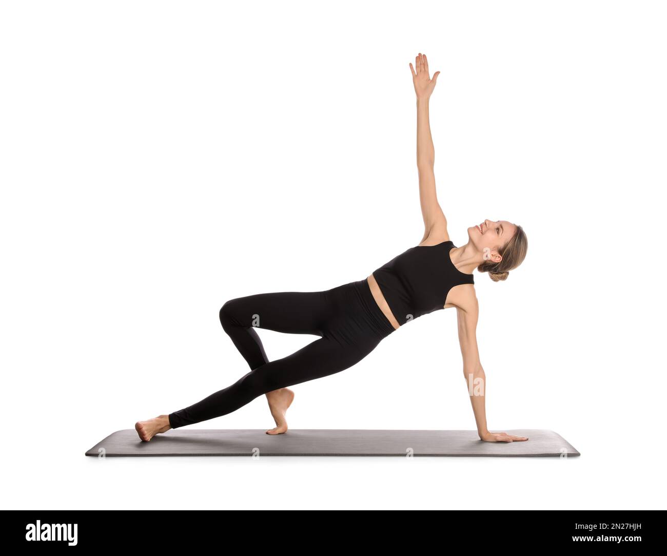 Giovane donna in abbigliamento sportivo che pratica yoga su sfondo bianco Foto Stock