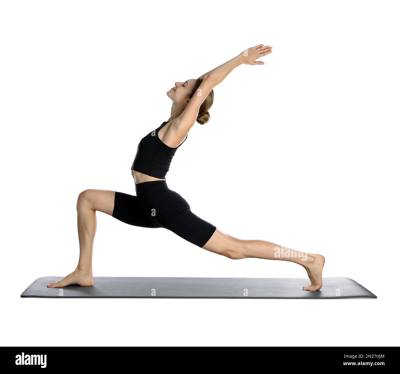 Giovane donna in abbigliamento sportivo che pratica yoga su sfondo bianco Foto Stock