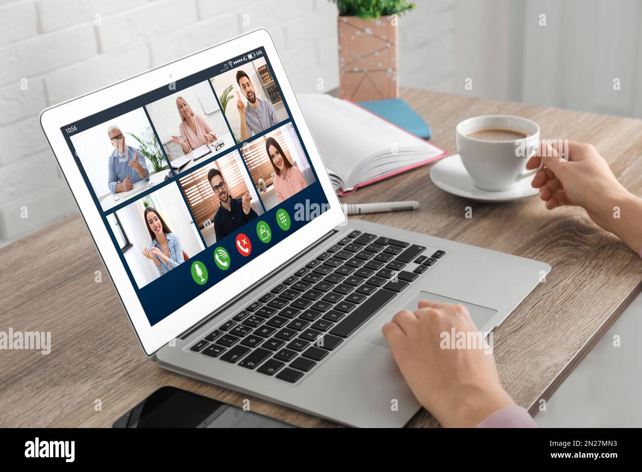 Donna che ha video chat con i colleghi al tavolo in ufficio, primo piano. Lavoro di squadra Foto Stock
