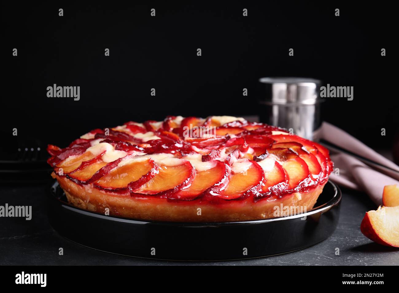 Deliziosa torta con prugne sulla tavola grigia Foto Stock
