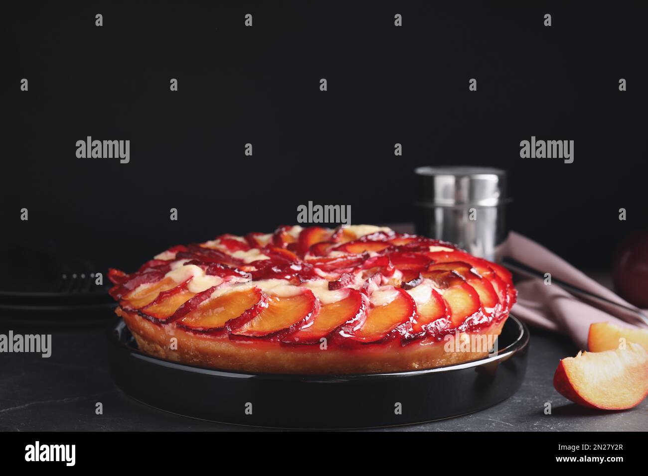 Deliziosa torta con prugne sulla tavola grigia Foto Stock