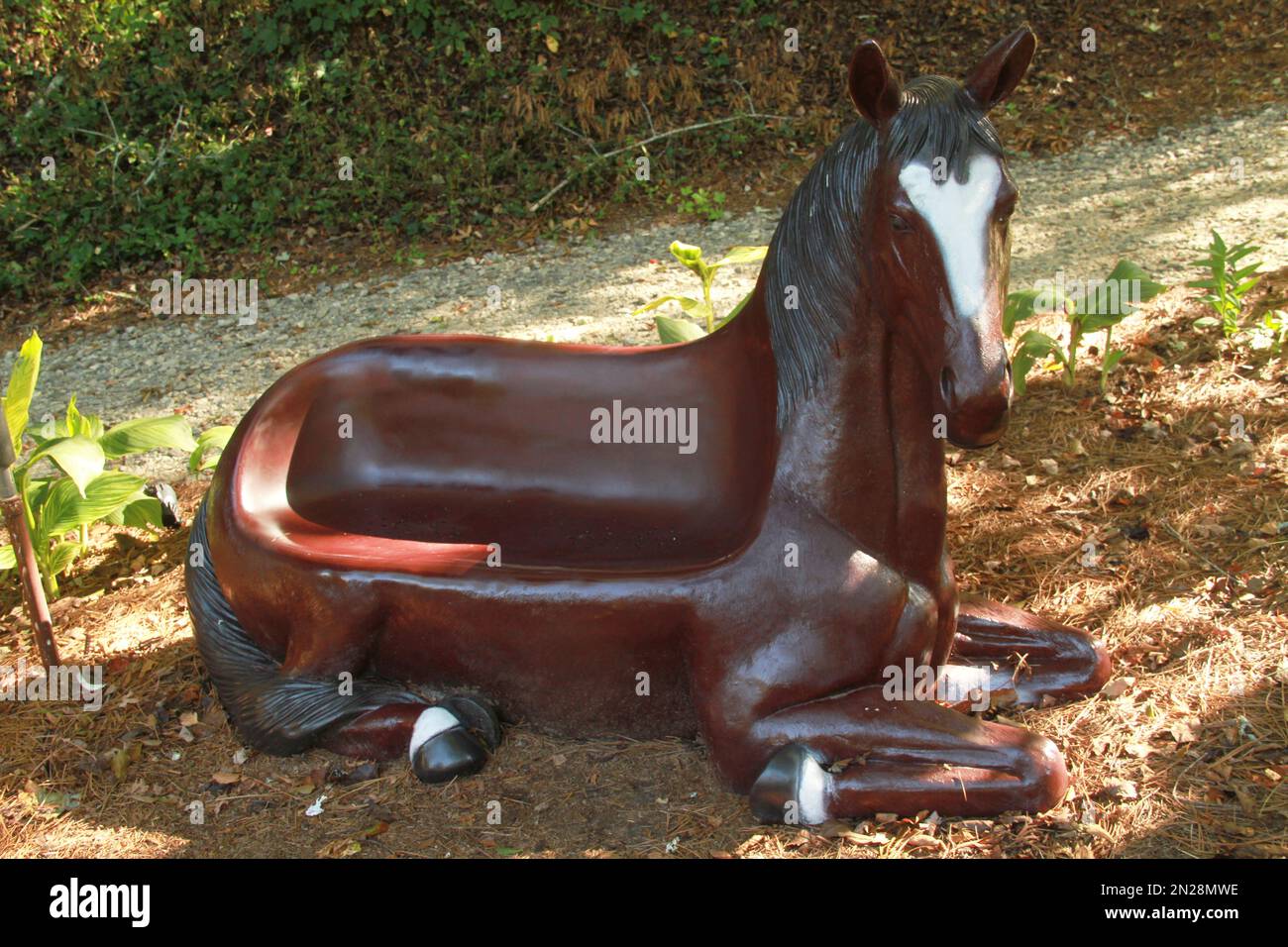 Panchina in un parco a forma di cavallo Foto Stock