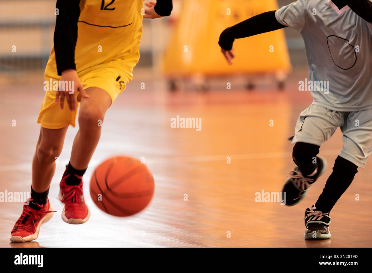 ragazzi che giocano una partita di basket al coperto. Foto Stock