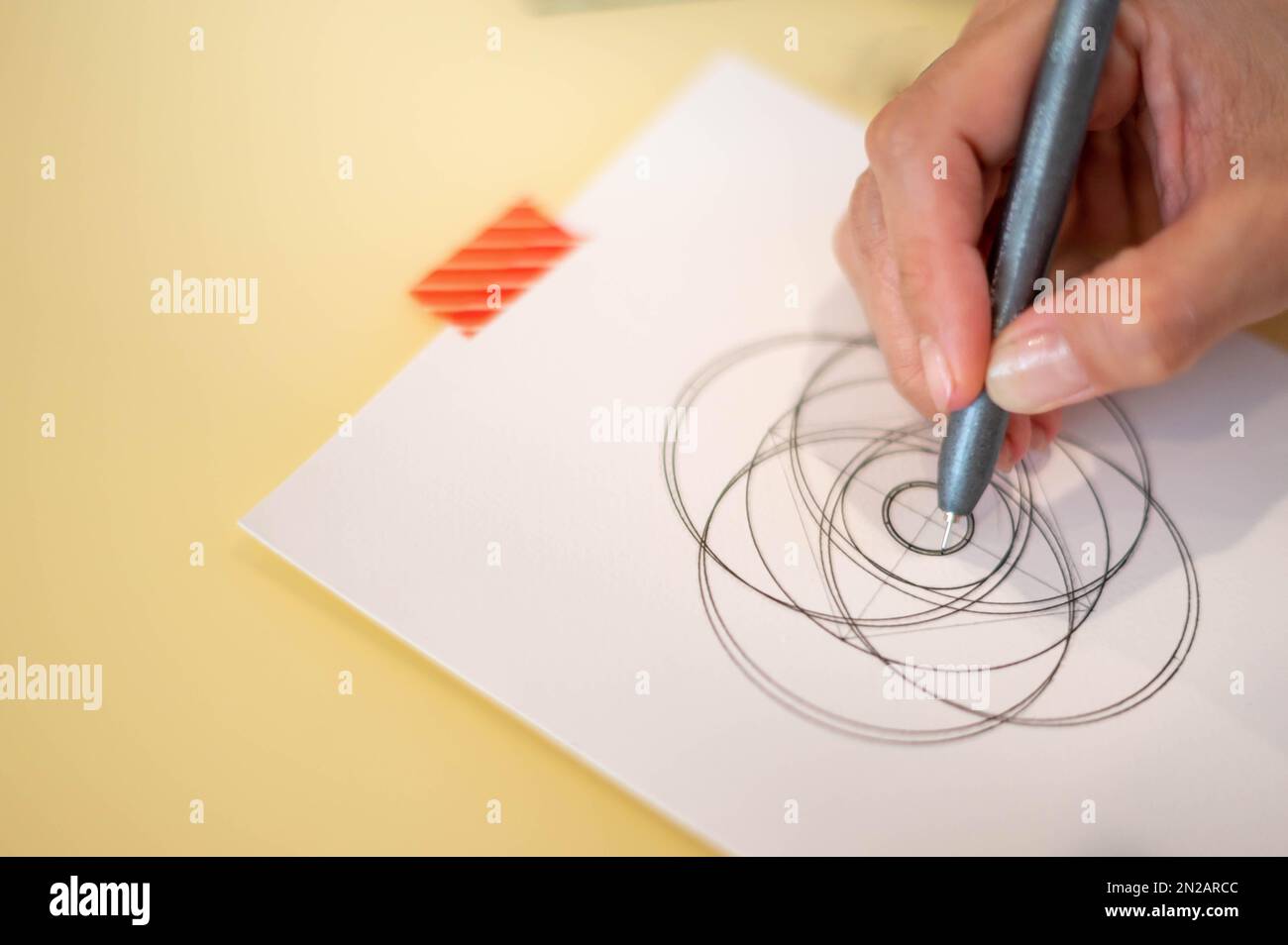 Mano femminile utilizzando una penna magica nera che si prepara a disegnare  e disegnare il concetto di mandala sul white paper vuoto Foto stock - Alamy