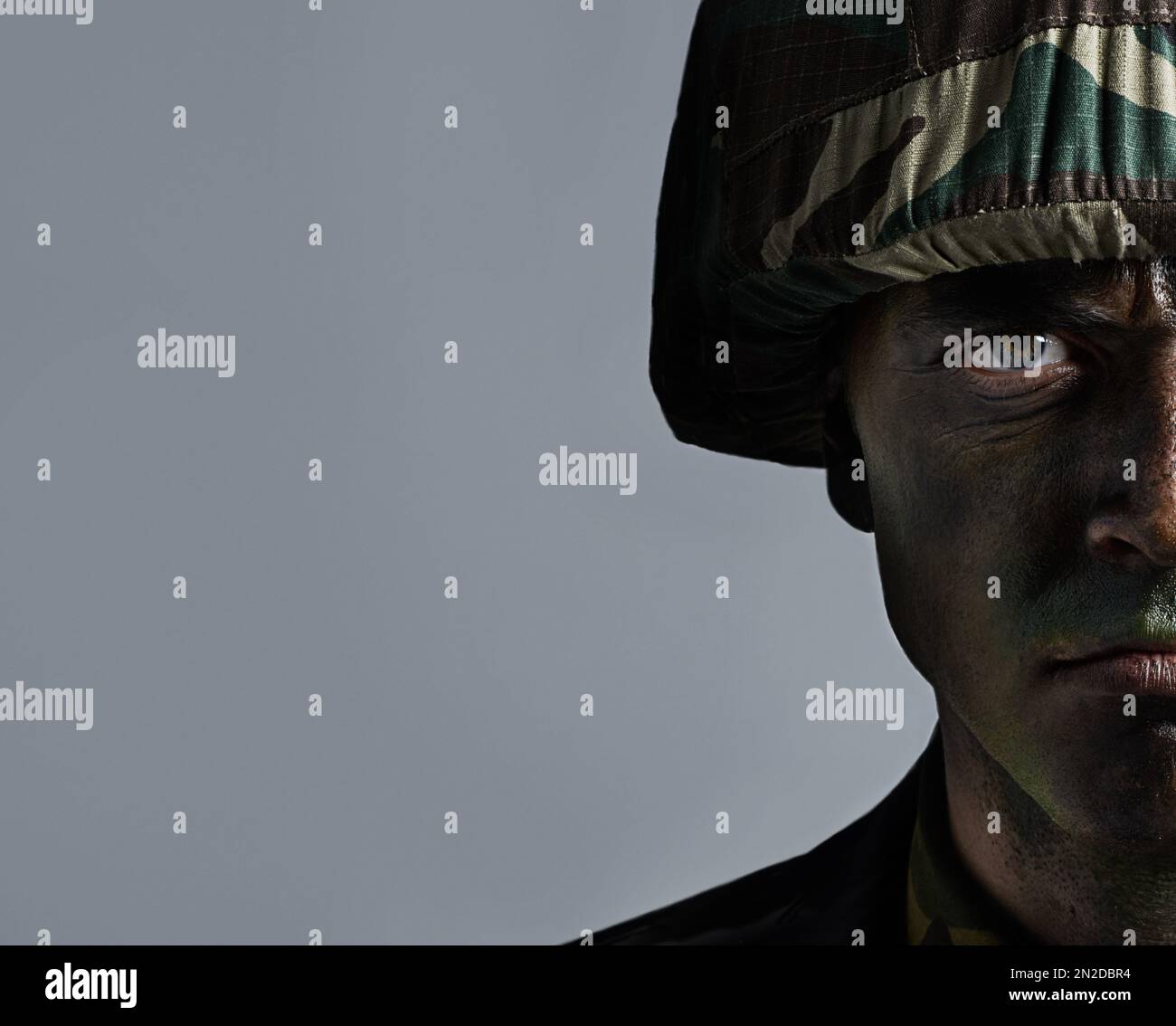 Pronti per la guerra. Colpo di testa di un serio militare con il volto mimetlato. Foto Stock