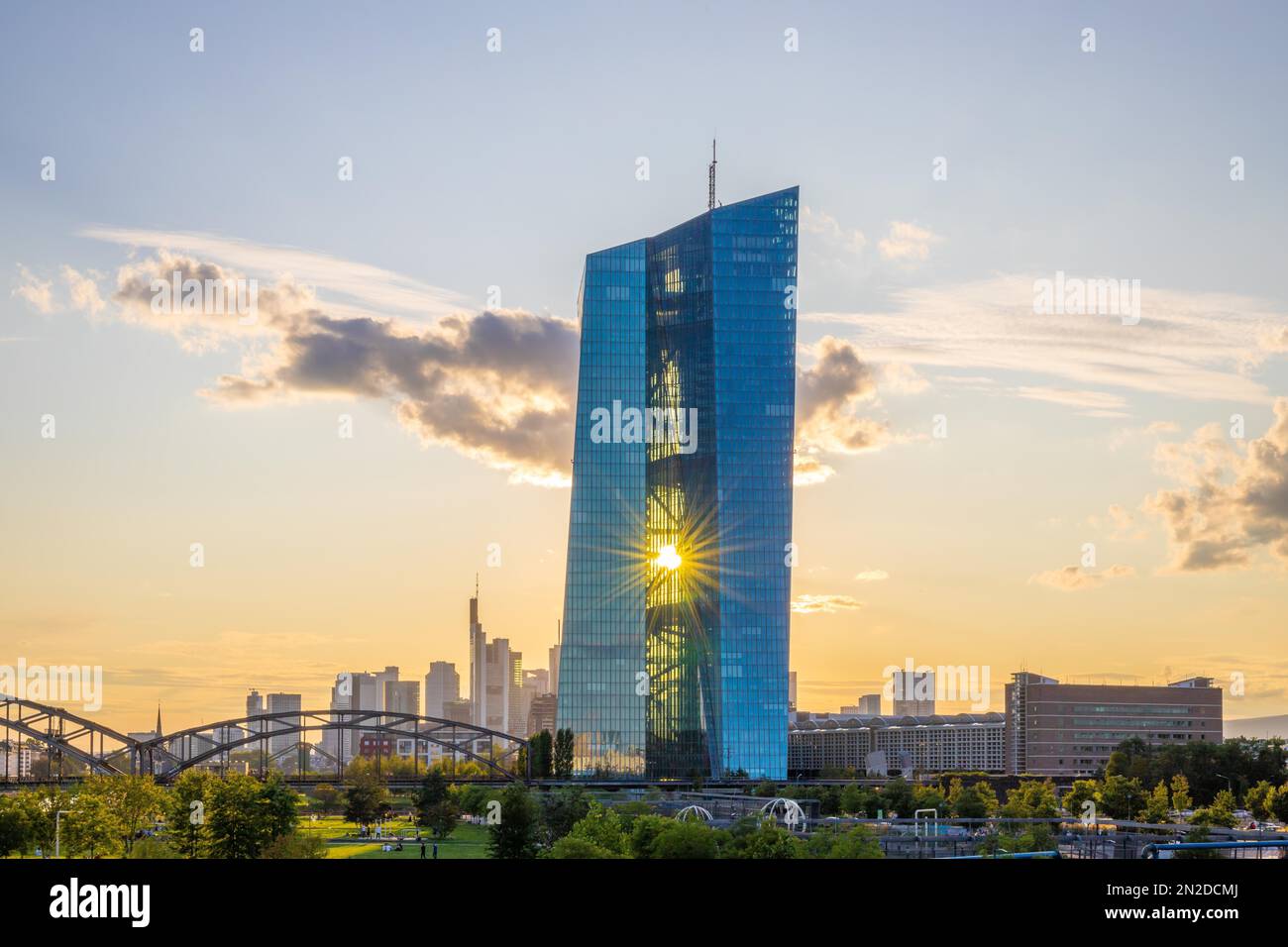 La Banca Centrale europea, BCE, all'ora d'oro, con il riflesso del sole nella facciata di vetro e raggi di luce solare dal Ponte Ignatz Bubis Foto Stock