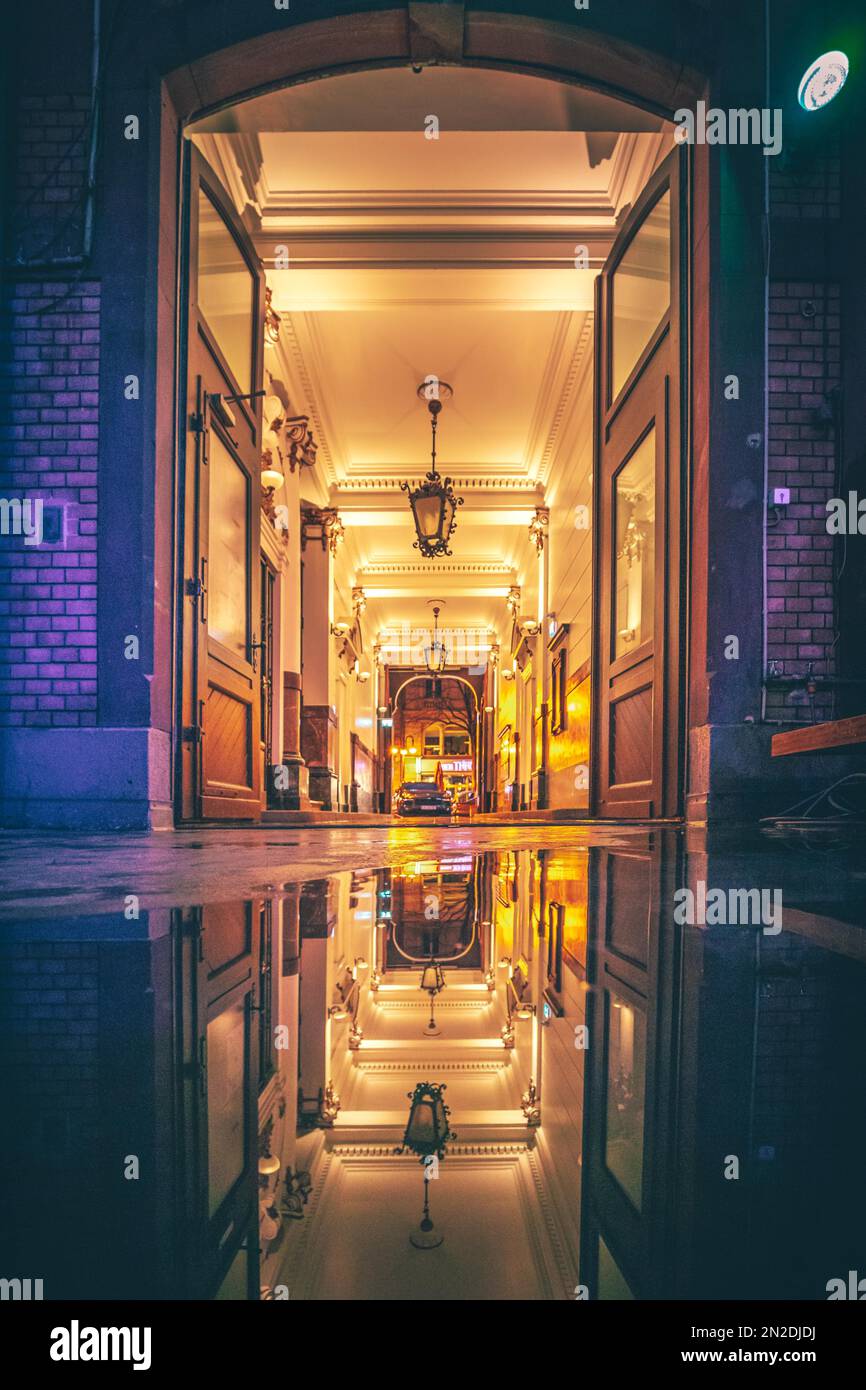 Ingresso della casa di notte, passaggio illuminato, con riflessione sul pavimento. Assia, Germania Foto Stock