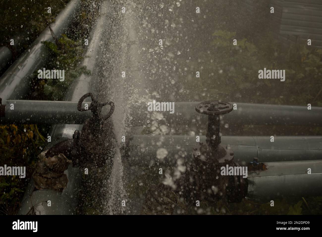 Fuoriuscita di acqua dal tubo rotto. Innovazione della pipeline. Incidente nella stazione di caldaia. Flusso di acqua. Foto Stock