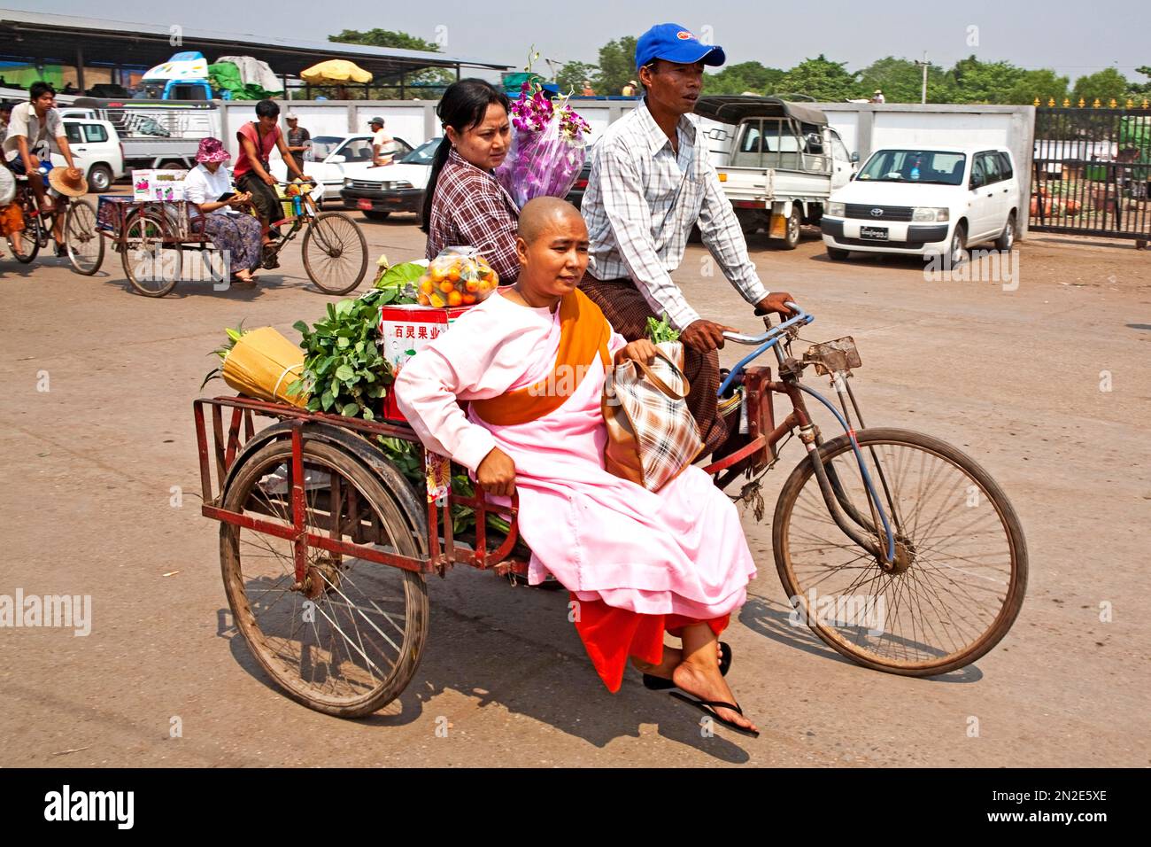 Monaco femminile sul risciò ciclo, Thiri Mingaleay mercato vegetale, Yangoon, Myanmar, Yangoon, Myanmar Foto Stock