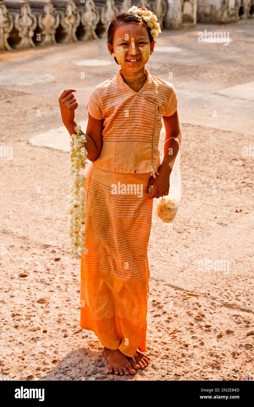 Ragazza con collana di fiori di fronte al Monastero di Shwenandaw, Mandalay, Myanmar Foto Stock