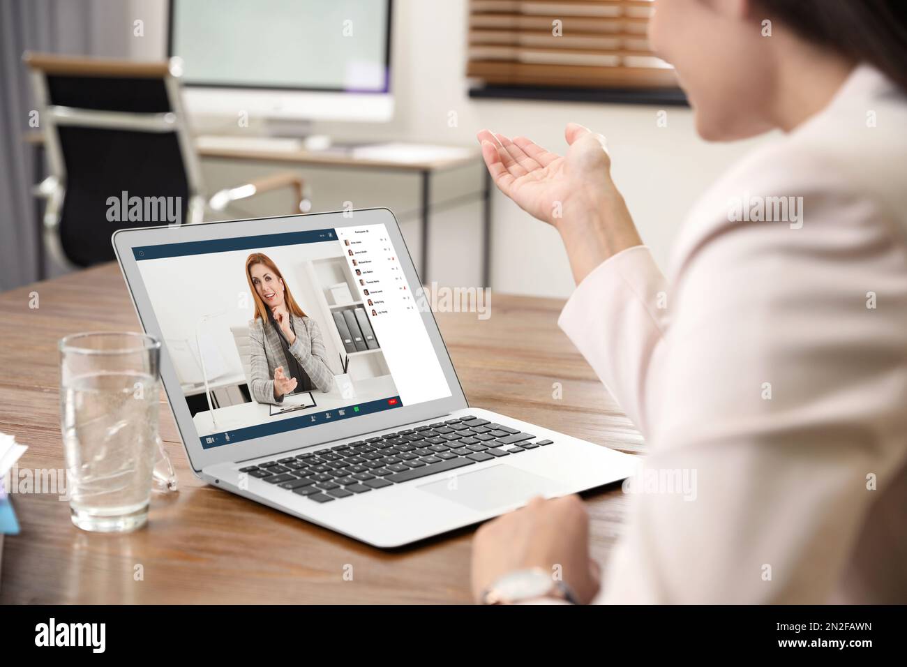 Donna che ha video chat con la squadra al tavolo, primo piano Foto Stock