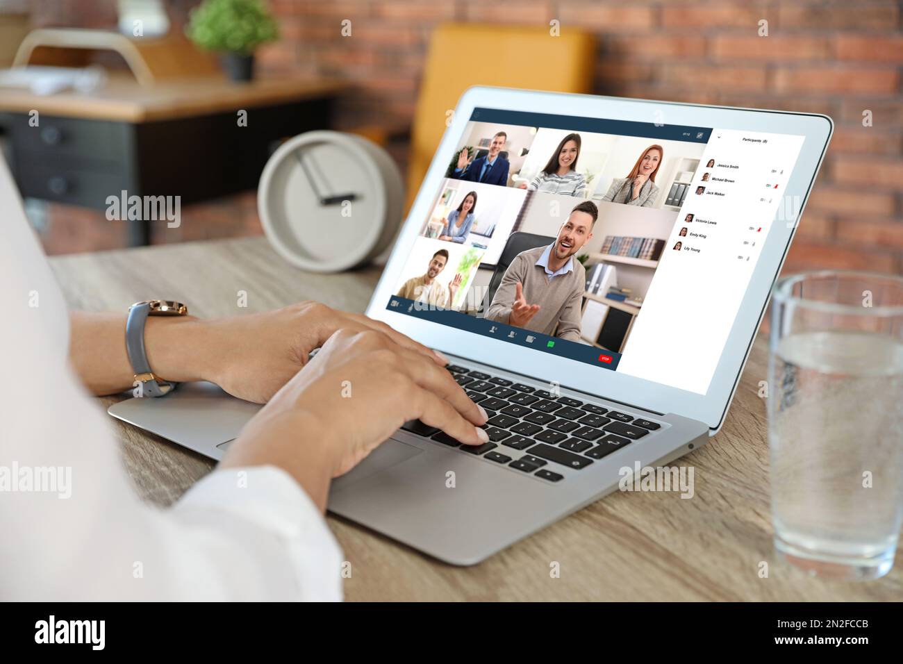 Donna che ha video chat con la squadra al tavolo, primo piano Foto Stock