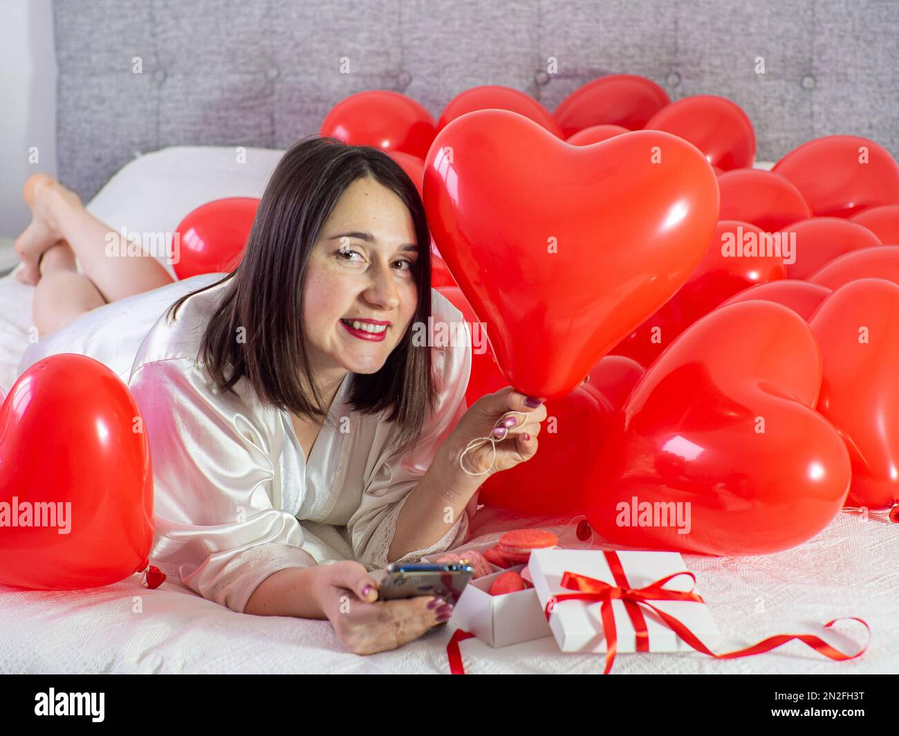 Donna sdraiata in decorazioni con palloncini per la festa di San Valentino  Foto stock - Alamy