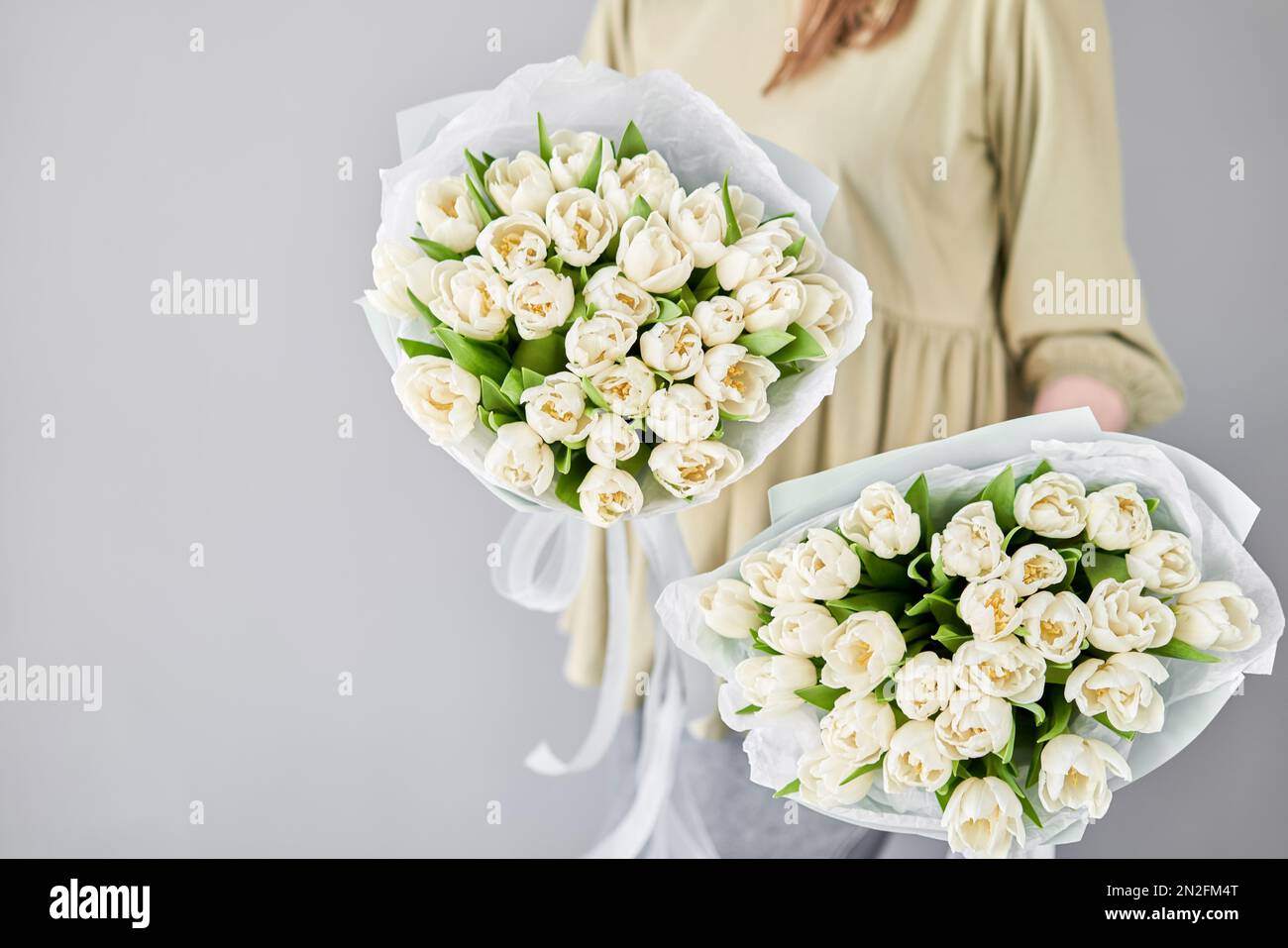 Fiorista donna crea bello due bouquet di tulipani crema primavera. Concetto  di negozio floreale europeo. Bel mazzo fresco. Istruzione, maestro Foto  stock - Alamy