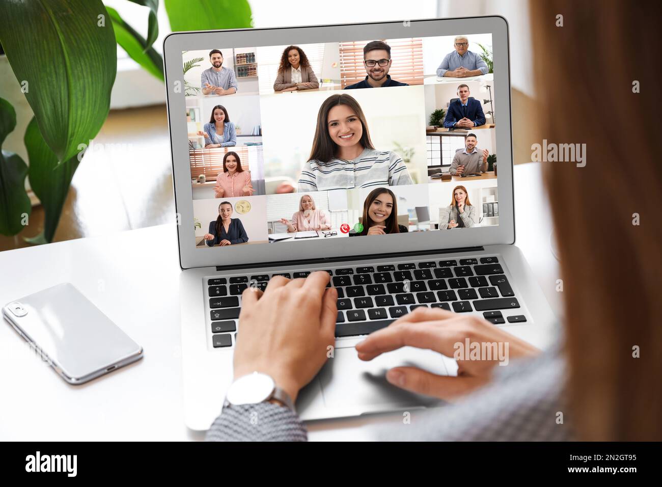 Donna che ha video chat con la squadra al tavolo, primo piano Foto Stock