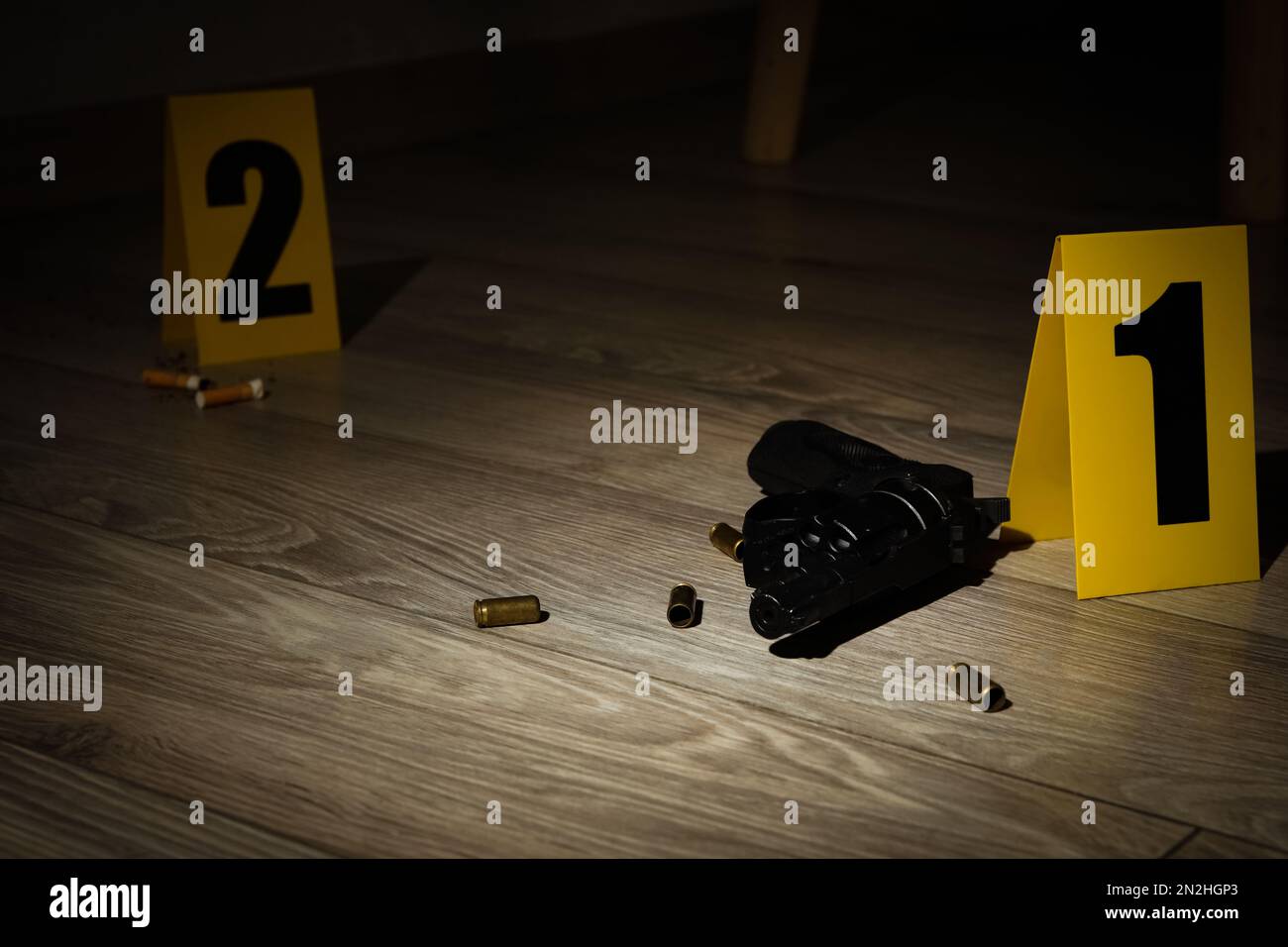 Gun e gusci su pavimento di legno in scena crimine Foto Stock