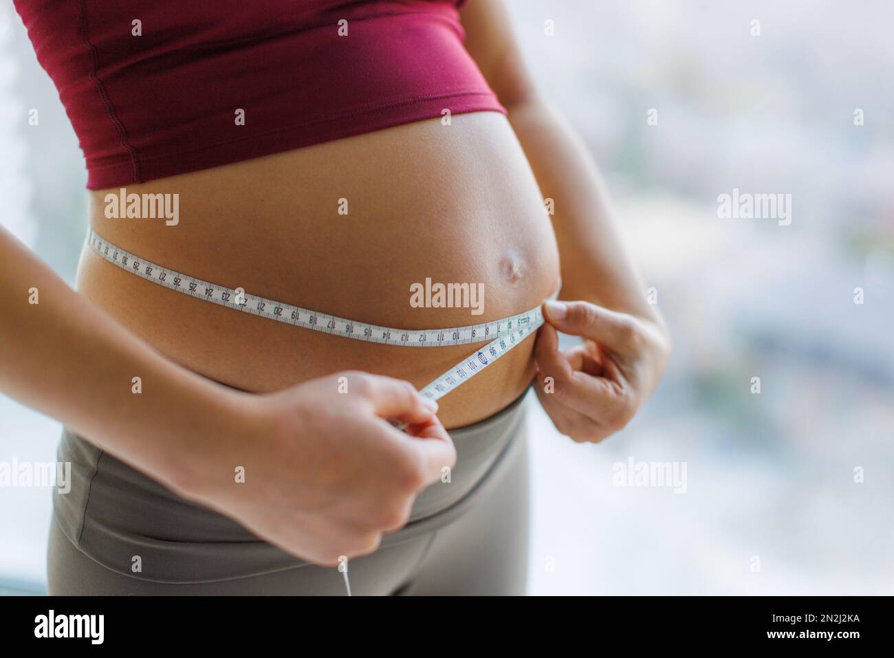 Donna incinta che misura il ventre. Gravidanza sana. Baby Bump di donna incinta primo piano. Immagine concettuale della cura prenatale, della maternità, della salute, della medicina Foto Stock