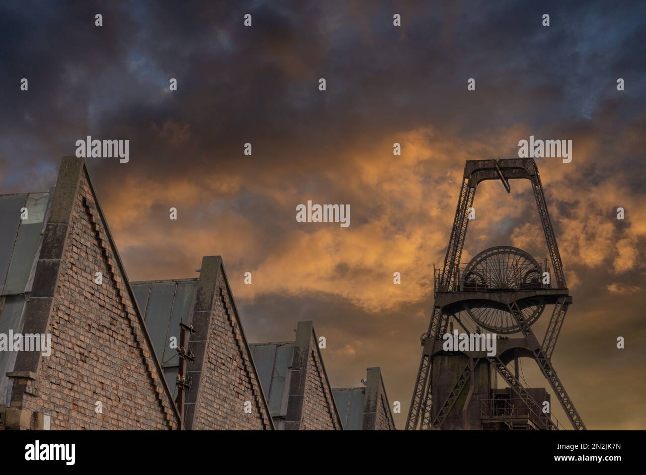 Testa di pozzo al tramonto. Colliery ruota di avvolgimento al tramonto. Silhouette simbolica per miniere di carbone e minatori. Inghilterra settentrionale Foto Stock