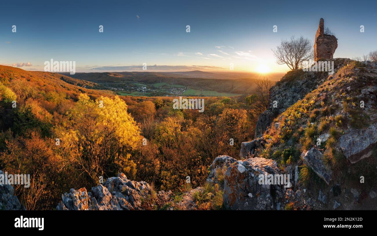 Autunno colorato tramonto con villaggio e foresta, Slovacchia - castello Pajstun Foto Stock