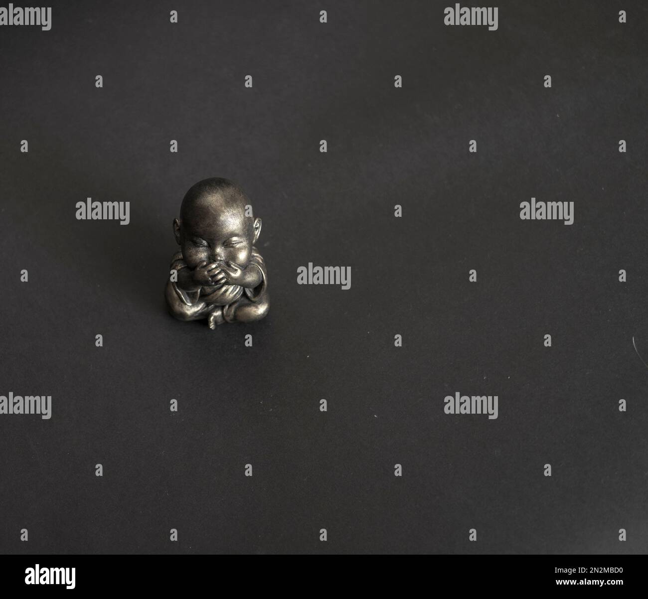 Statua del Buddha d'argento su sfondo nero Foto Stock