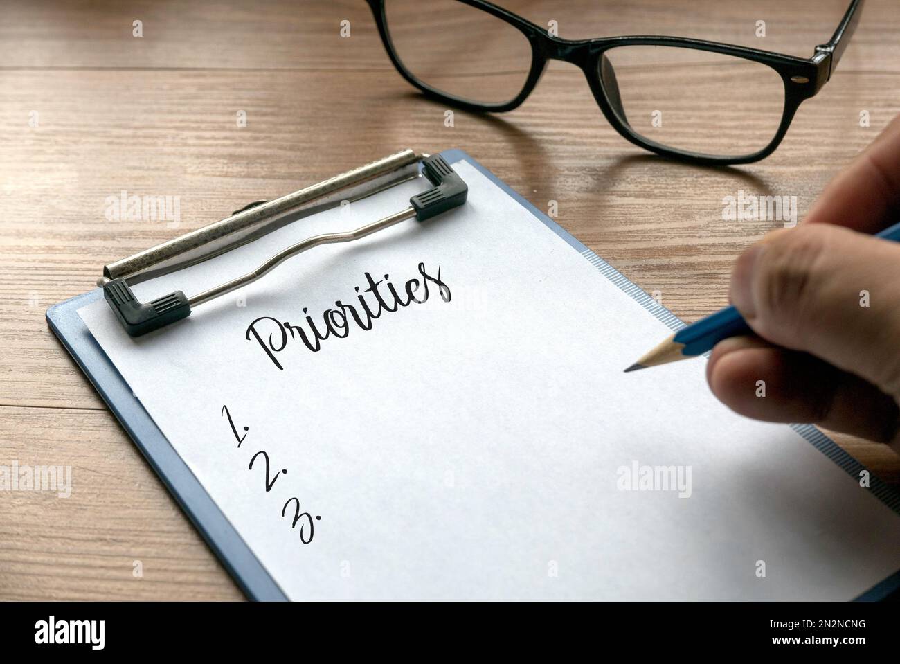 Focalizzazione selettiva delle priorità di scrittura a mano e un elenco di numeri su appunti con carta. Foto Stock