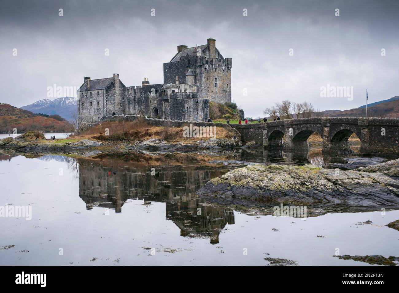 Scozia, Highlands, il castello medievale di Eilean Donan, Kyle of Lochalsh, vista invernale con lago Loch Alsh e montagne innevate Foto Stock