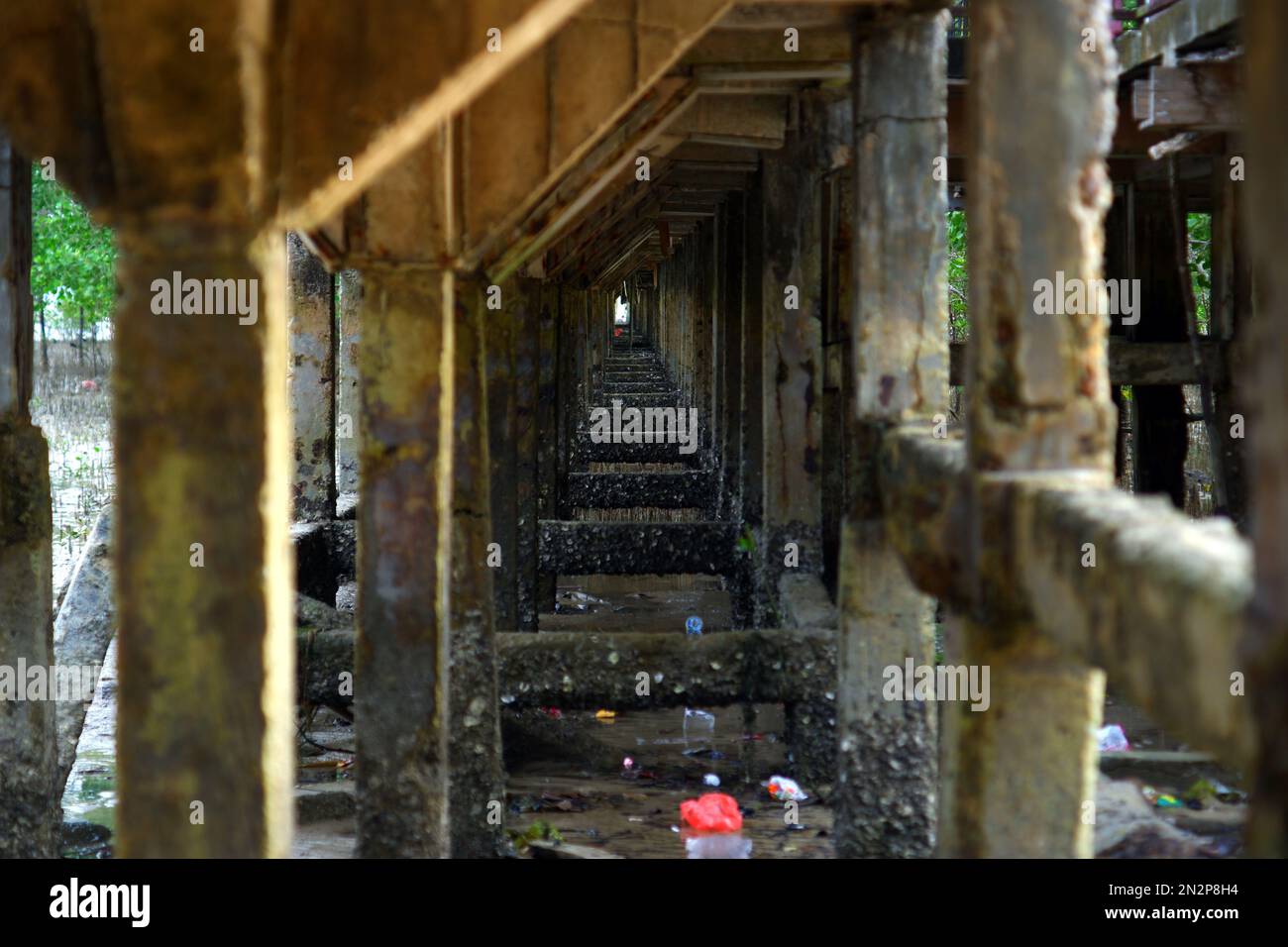 Pilastri o pilastri di cemento Pier Pillars dal lato destro, costruito sulla spiaggia, nel villaggio di Belo Laut durante il giorno Foto Stock