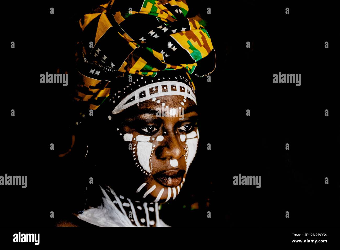 Donna africana in ritratto con pittura facciale e headdress. Foto Stock