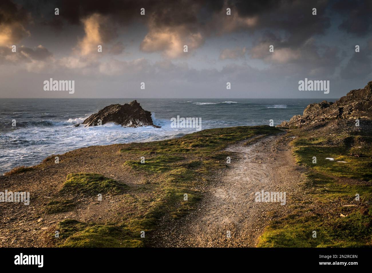 Luce serale su un sentiero accidentato sull'aspra Pentil Point East che conduce ad un punto panoramico dell'isola rocciosa chiamata Goose Rock sul coa Foto Stock