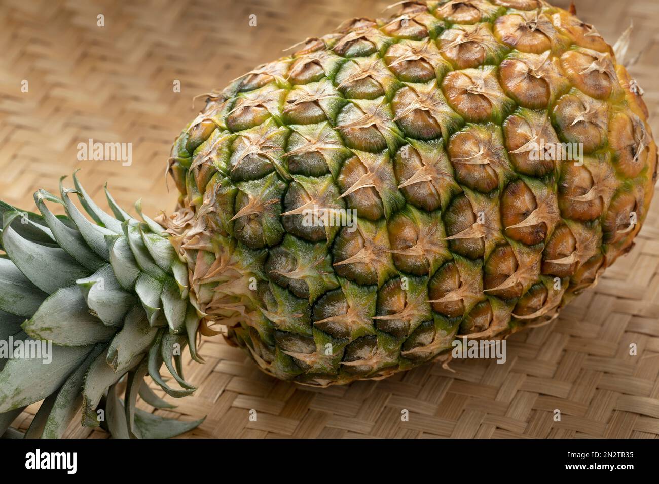 Singolo ananas maturo fresco intero primo piano su uno sfondo di vimini Foto Stock
