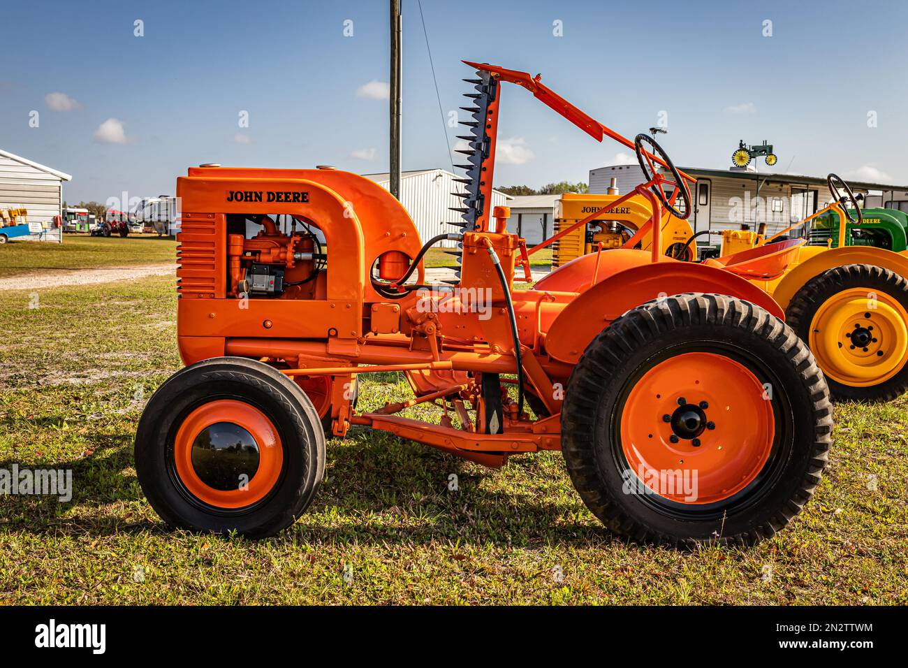 Fort Meade, FL - 22 febbraio 2022: Vista laterale in prospettiva alta di un trattore falciante John Deere modello li 1940 con falciatrice locale. Foto Stock