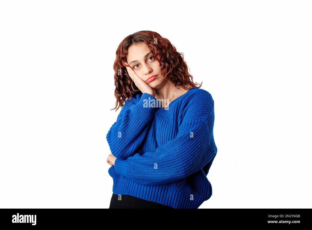 Donna carina in piedi isolato su sfondo bianco guardando riluttante e indivertito alla macchina fotografica, il viso appoggiato sulla mano. Ascoltare noioso persona. Ascolta Foto Stock