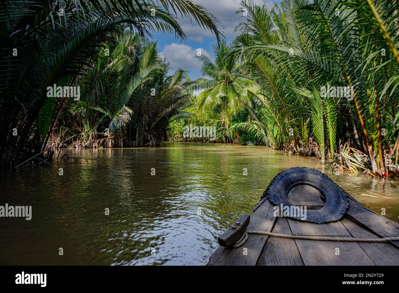 Una piccola barca che viaggia lungo un canale nella regione del Delta del Mekong nel Vietnam meridionale Foto Stock