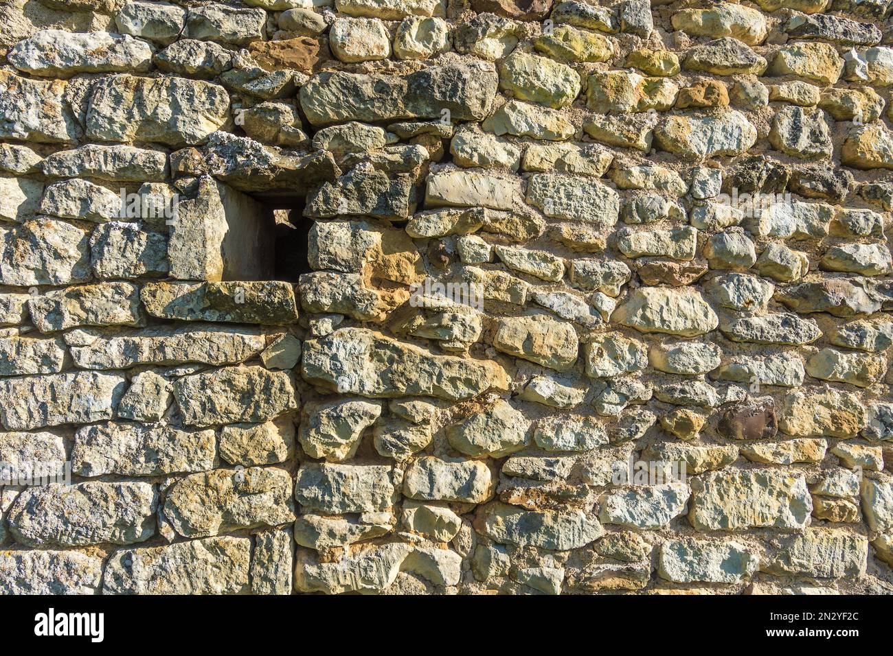 Casuale muro di pietra di casa con piccola apertura finestra aperta - Francia. Foto Stock