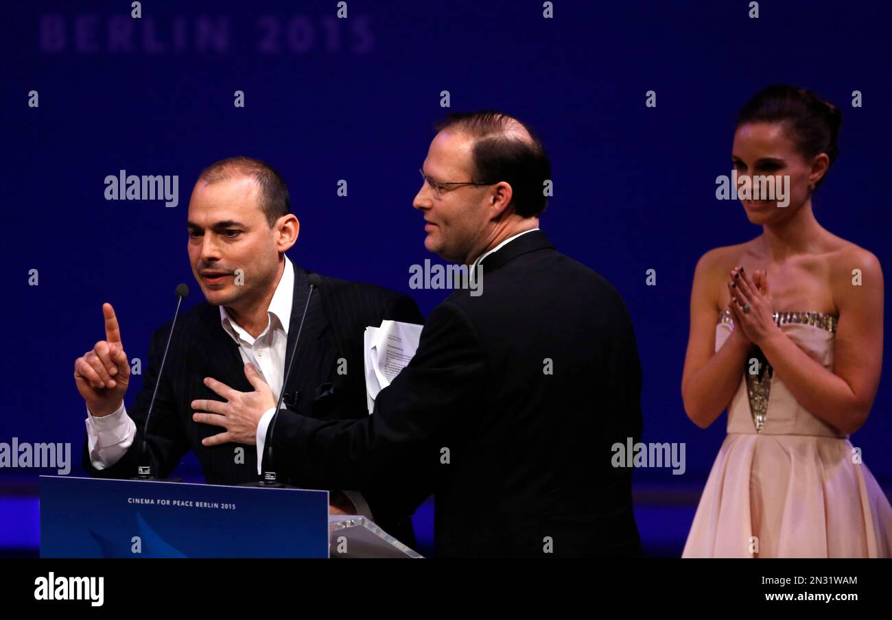 Political con-artist Igor Vamos is led off the stage as actress Natalie Portman applauds during the Cinema for Peace gala in Berlin, Monday, Feb. 9, 2015. (AP Photo/Markus Schreiber) Foto Stock