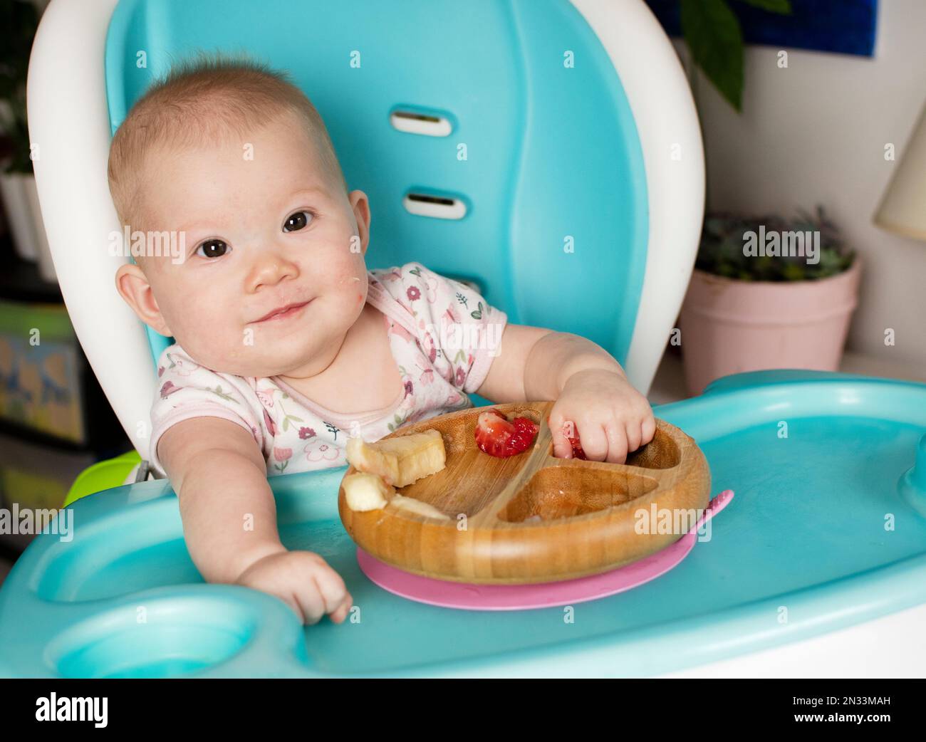 Bambino mangiare broccoli. Svezzamento guidato dal bambino. Svezzamento. Mangiare sano. Bambina caucasica seduta su un seggiolone e pranzo Foto Stock