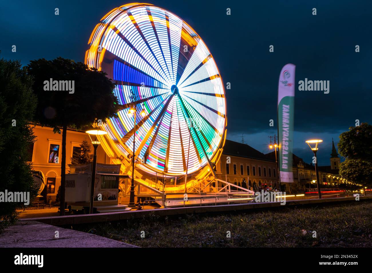 Lunga esposizione ripresa di una ruota panoramica in movimento illuminata di notte, Balassagyarmat, Ungheria Foto Stock