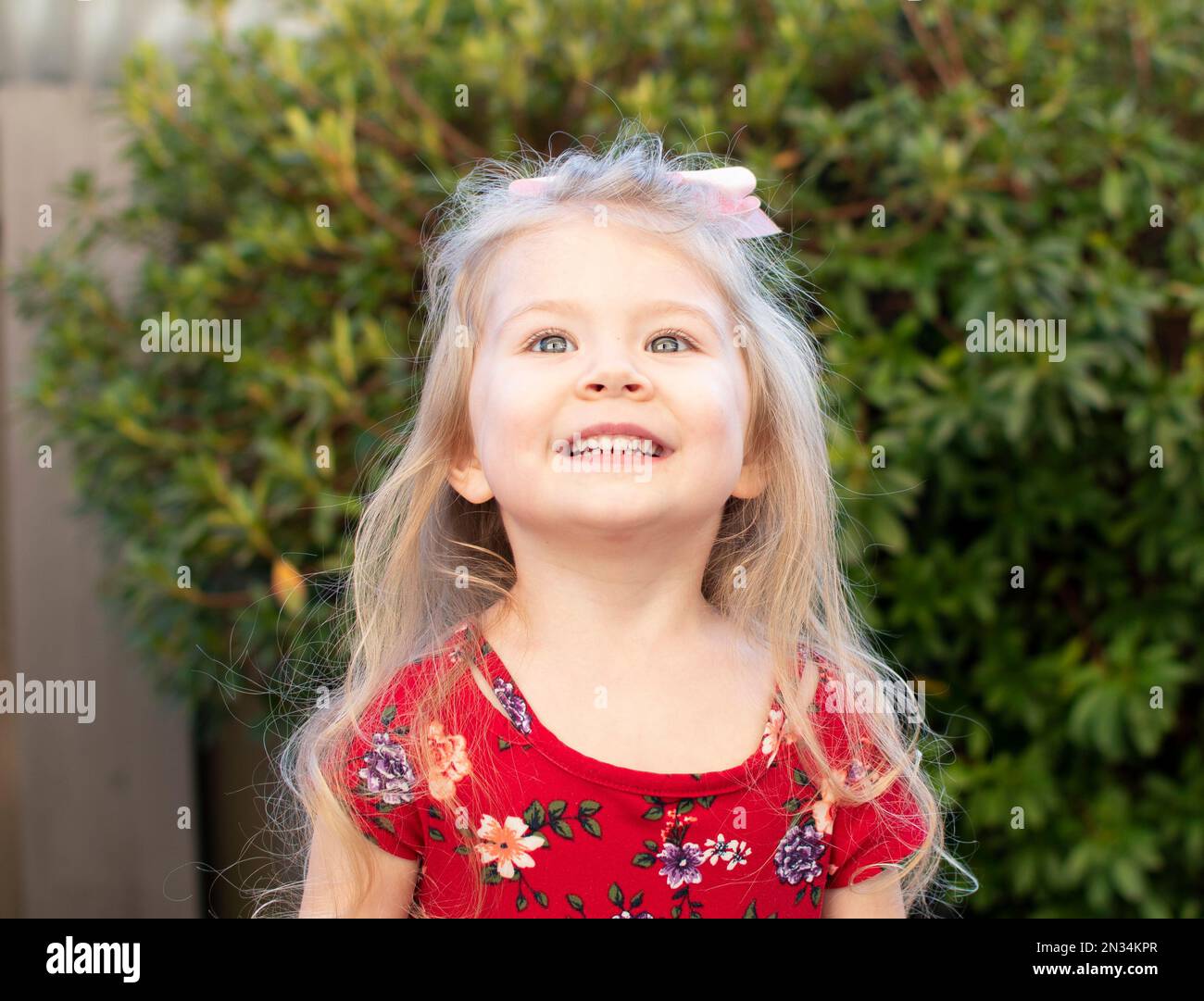 Una bambina sorridente e speranzosa Foto Stock