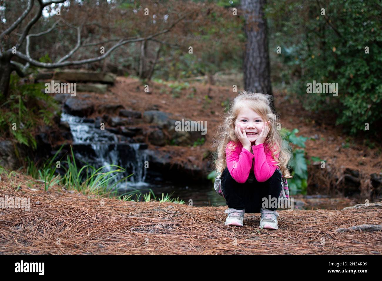 Bambina sorridente in un parco. Bionda caucasica in un'escursione Foto Stock