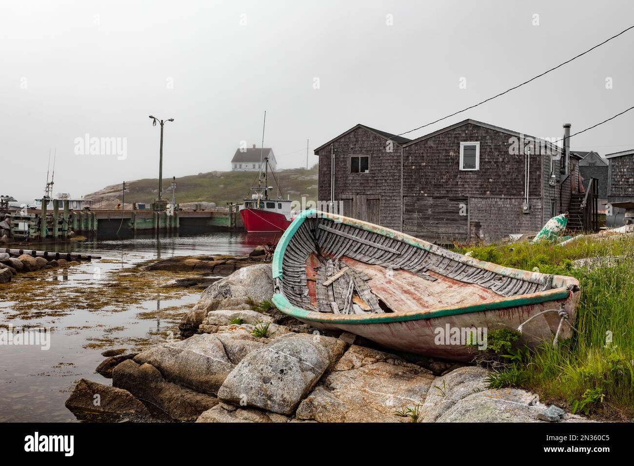 La nebbia scorre sull'iconico villaggio di Peggy's Cove, aggiungendo un look sgranato a tutto. Foto Stock