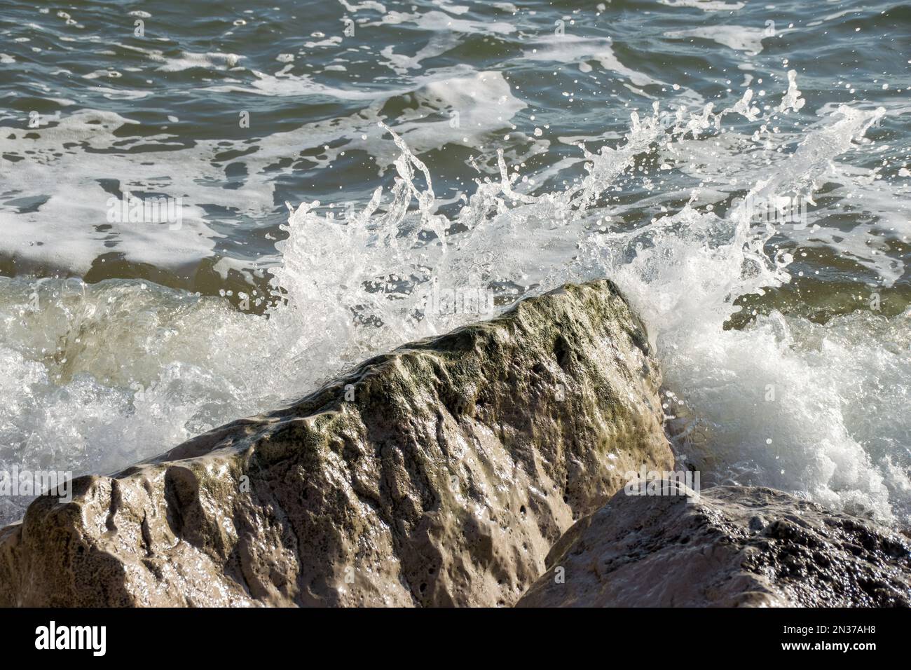 onde schizzare sulle rocce in mare Foto Stock