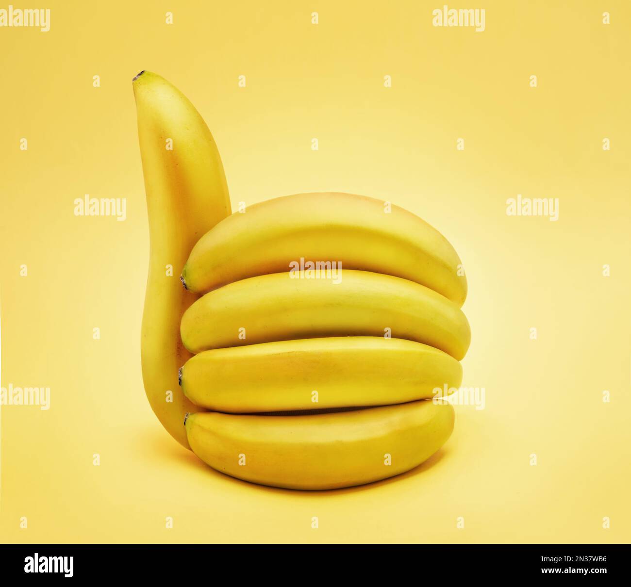 Banana pollici fino segno isolato su sfondo giallo. Foto Stock