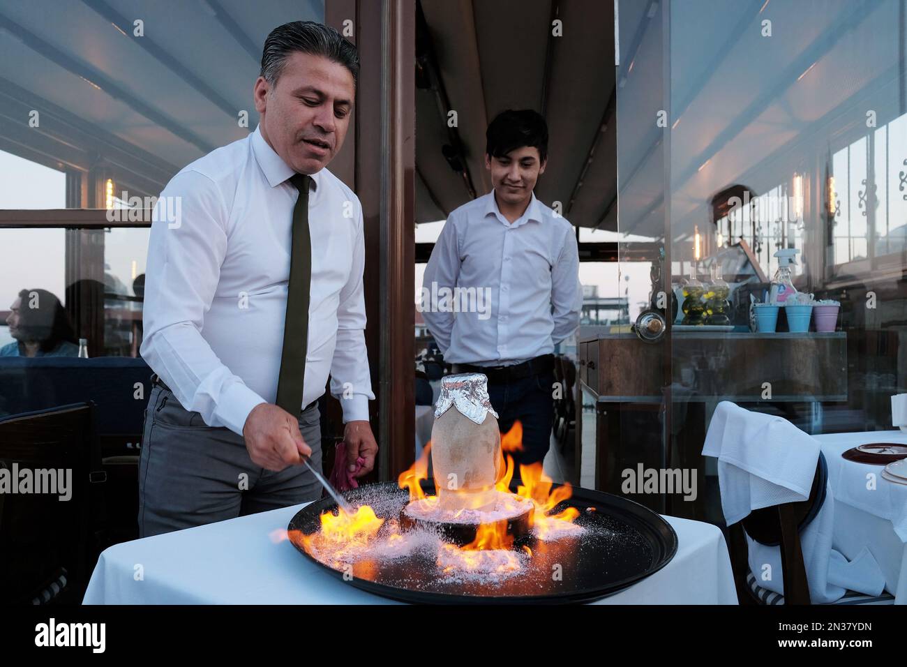 Chef che prepara il piatto nazionale turco, testi Kebab, nel piatto che si rompe prima dell'uso, in un ristorante sul tetto a Istanbul, Turchia. Foto Stock