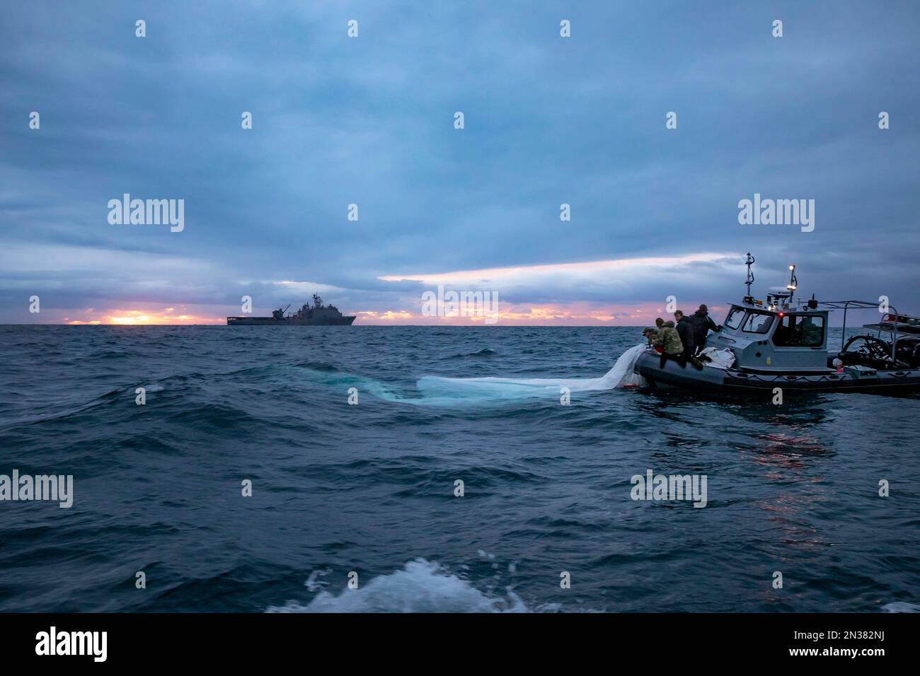 I marinai assegnati all'esplosivo Ordnance Disposal Group 2 recuperano una mongolfiera di sorveglianza ad alta quota al largo della costa di Myrtle Beach, South Carolina, mentre la nave portuale Harpers Ferry USS carter Hall (LSD 50) transita nelle vicinanze, il 5 febbraio 2023. EODGRU 2 è una parte fondamentale della forza di combattimento navale che elimina i pericoli esplosivi per fornire accesso alle aree negate; assicura il dominio sottomarino per la libertà di movimento; costruisce e promuove relazioni con partner di fiducia e protegge la patria. Sotto la guida del Presidente degli Stati Uniti e con il pieno sostegno Foto Stock