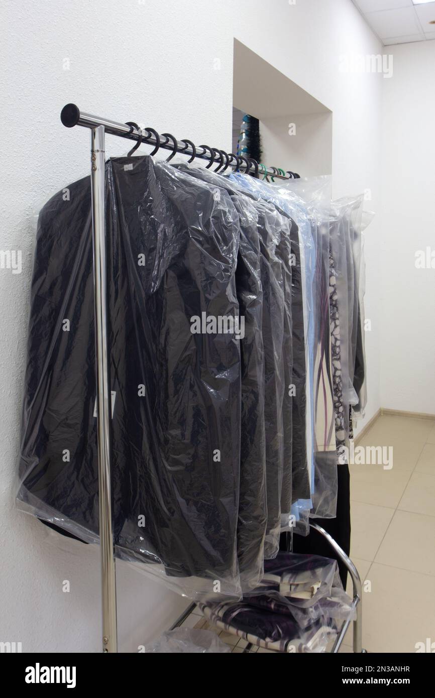 Appendiabiti con abiti da uomo e da donna per il defunto in un negozio di articoli funerari. I vestiti in cui il defunto è scortato all'ultimo viaggio. Foto Stock