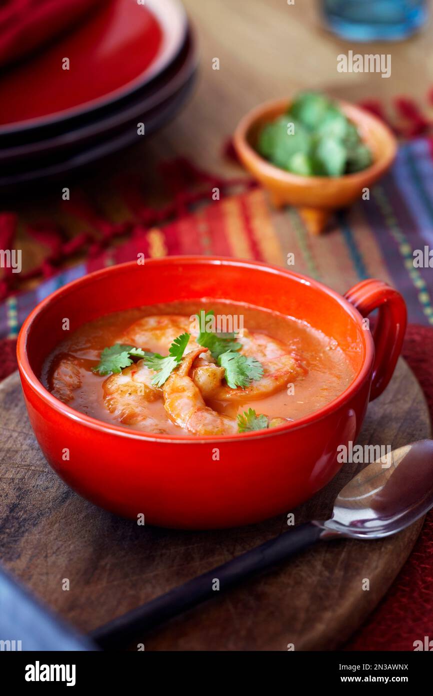 Zuppa di pomodoro e gamberi in un recipiente rosso con coriandolo Foto Stock