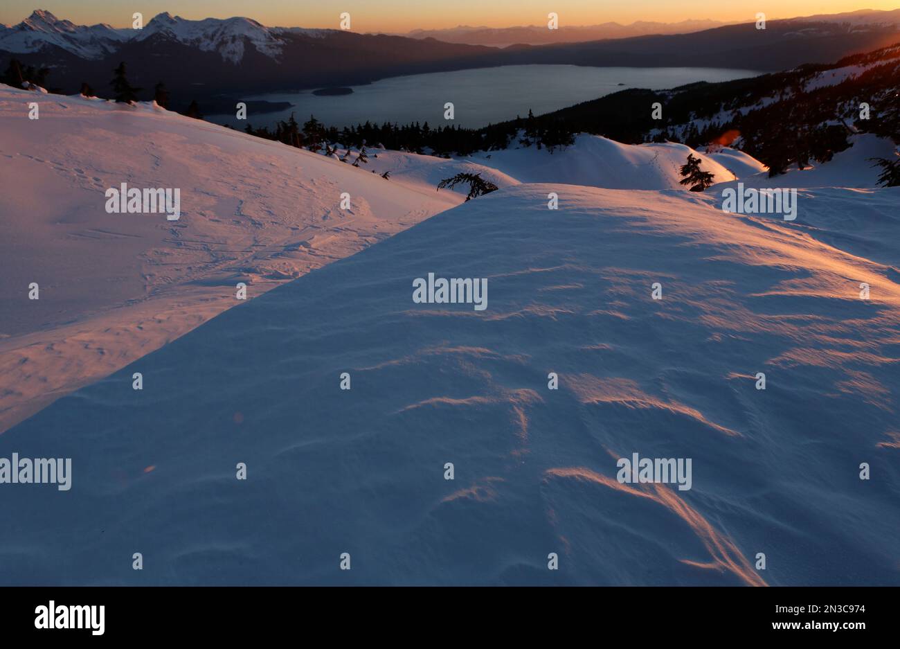 I venti di Taku soffiano creste ghiacciate che incorniciano una vista del passaggio interno dall'Isola Douglas e della Foresta Nazionale di Tongass vicino a Juneau Foto Stock