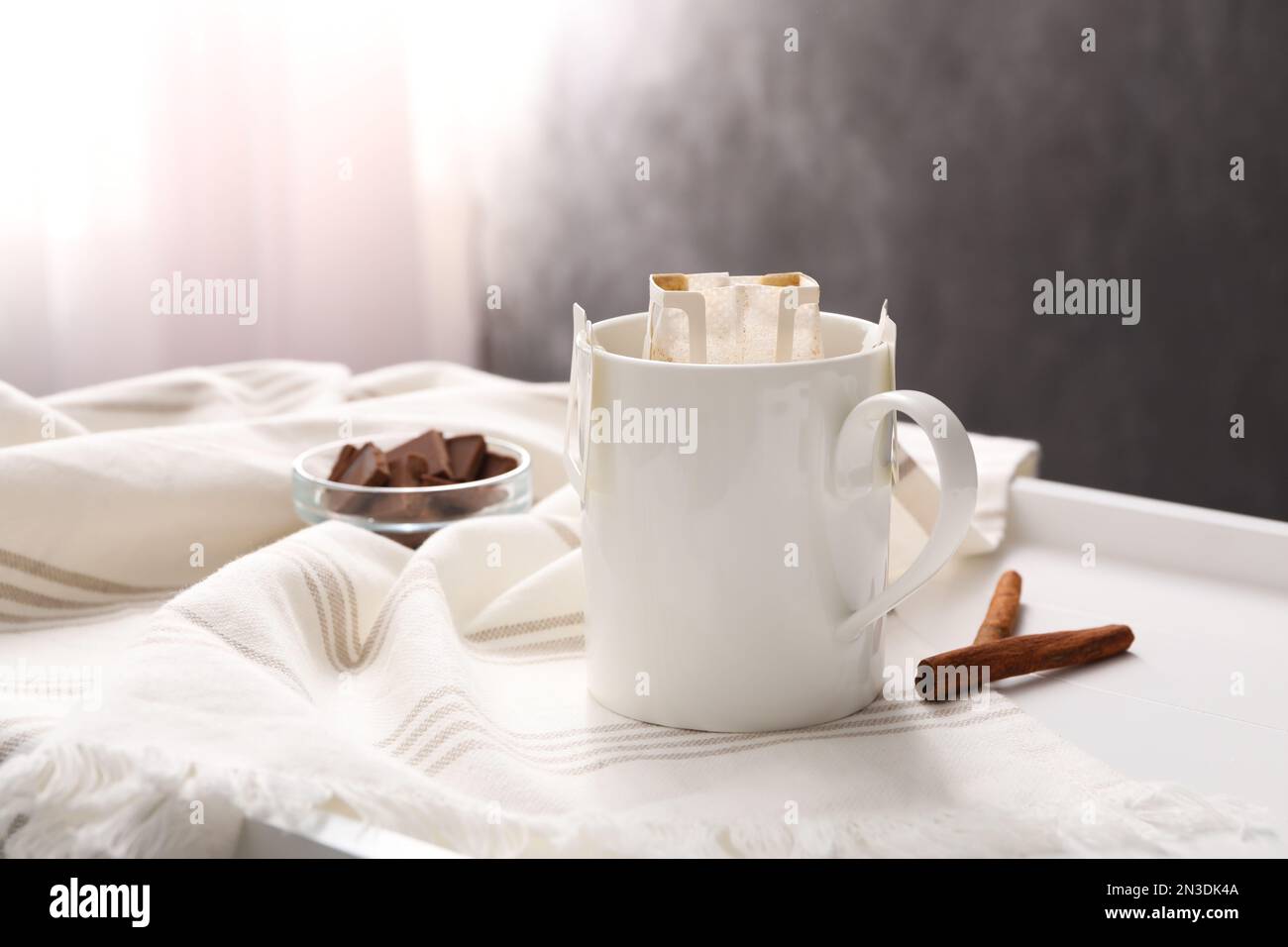 Una tazza di caffè con bastoncini di cannella su un piatto