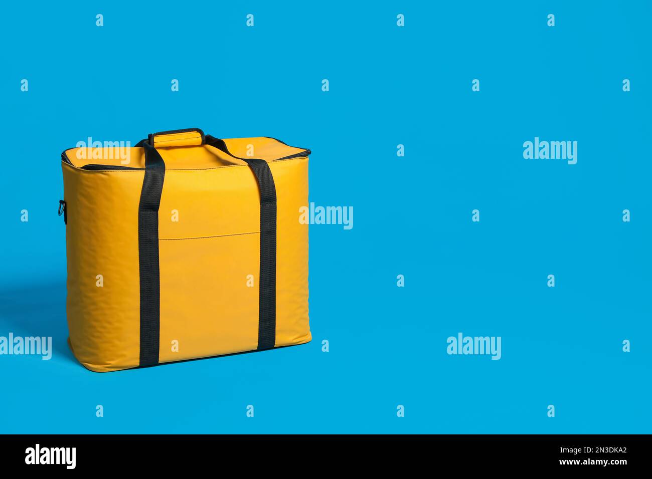 Moderna borsa termica gialla su sfondo azzurro. Spazio per il testo Foto  stock - Alamy
