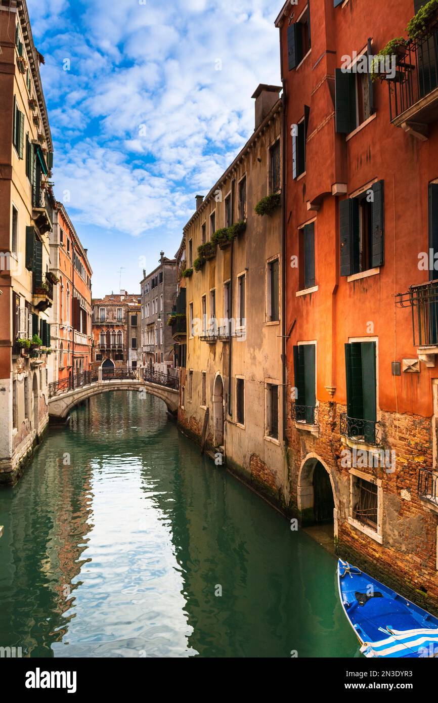 Tipici edifici in pietra e vista attraverso un canale con una passerella pedonale in Veneto; Venezia Italia Foto Stock